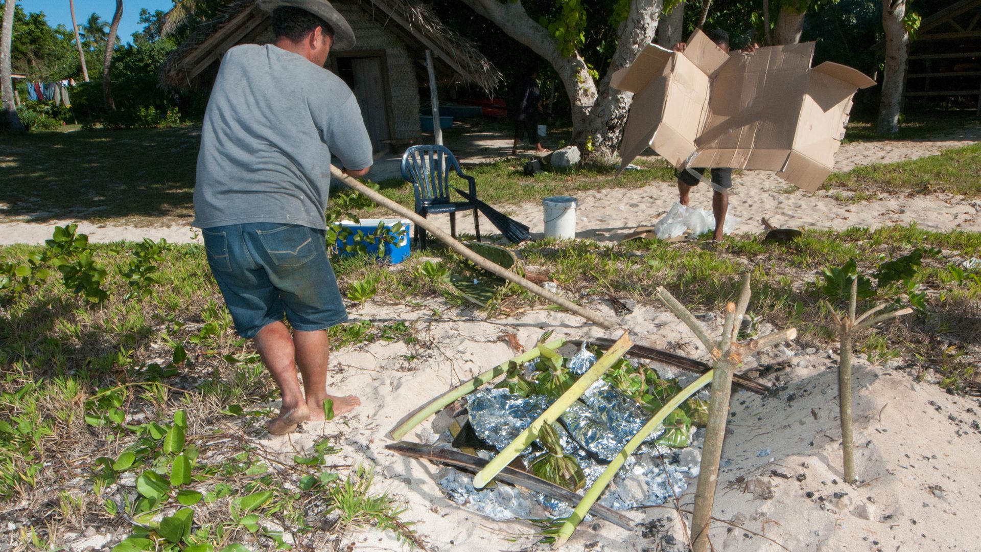 Cooking in a tradition Tongan 'umu or underground oven